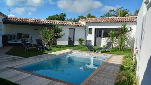 une cour arrière avec une piscine et une maison dans l'établissement PINS EN RE, à Rivedoux-Plage