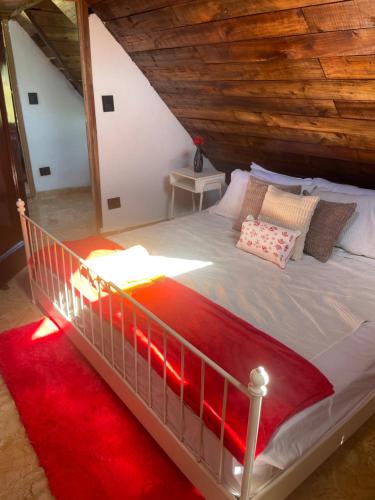 a bedroom with a large bed with a red rug at Dreamvilles Ecovillage Las Galeras in Las Galeras
