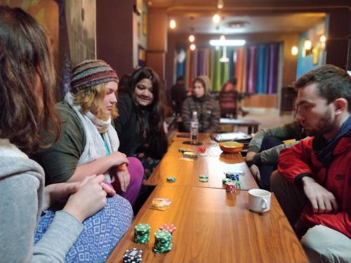 Un groupe de gens assis autour d'une table jouant aux dominos dans l'établissement Live Free Hostel Rishikesh, à Rishikesh