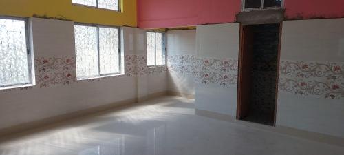 ein leeres Zimmer mit weißen Wänden und Fenstern in der Unterkunft MAA PG in Silchar