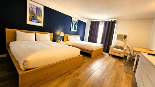 a hotel room with two beds and a desk at Cloud 9 Inn in Whitecourt