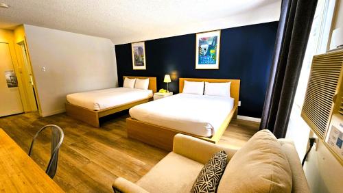 a hotel room with two beds and a couch at Cloud 9 Inn in Whitecourt