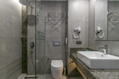ein Bad mit einem Waschbecken, einem WC und einer Dusche in der Unterkunft Lara Park Hotel in Antalya