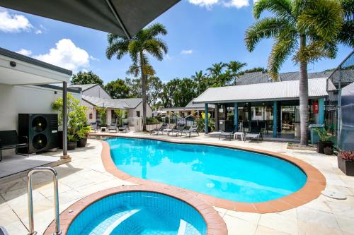 a swimming pool in a yard with a house at Nautilus Noosa Resort in Noosaville