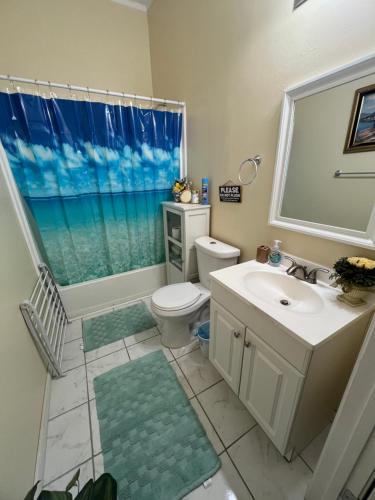 uma casa de banho com um lavatório, um WC e uma janela. em Southern’s Beauty 1 Very close to Airport em Kenner