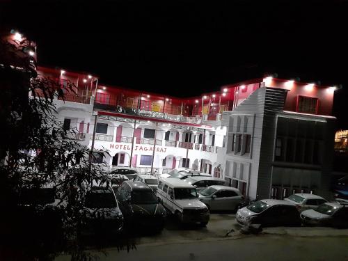 SītāpurにあるHotel Jagat Raj, Sitapurの駐車場車を停めた白い大きな建物
