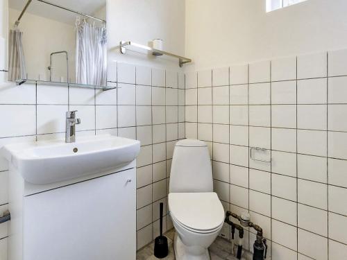 a white bathroom with a toilet and a sink at Holiday home Holeby in Holeby