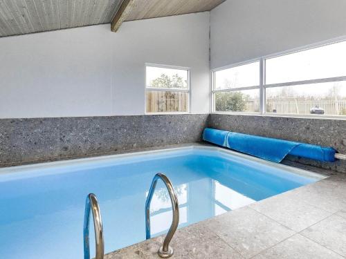 a large blue swimming pool with two chairs in it at 8 person holiday home in V ggerl se in Marielyst
