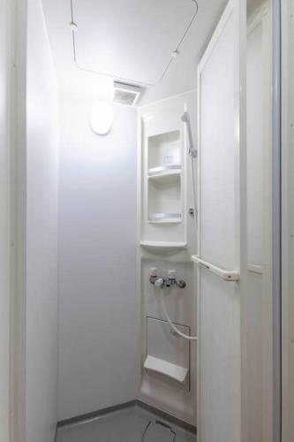 a white bathroom with white shelves and a refrigerator at Premier suite MEGURO Tokyo in Tokyo