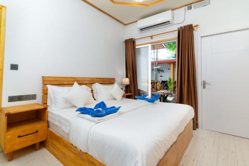 Tropico villa في أوكولهاس: غرفة نوم بسرير ابيض وعليه قوس ازرق
