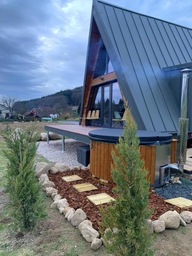 a house with a blue roof with a pathway in front at Les Atypiques Chalets in Barbey-Séroux