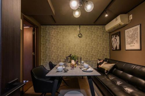 東京的住宿－Premier suite Nishiazabu Roppongi front，一间带桌子和真皮沙发的用餐室