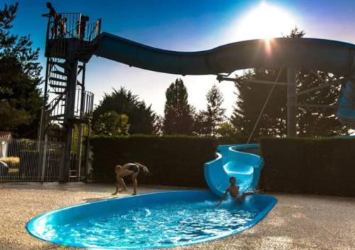 2 personnes jouant dans une piscine sur une aire de jeux dans l'établissement Mobil-Home LA PALMYRE - Zoo, plage, animations, aux Mathes