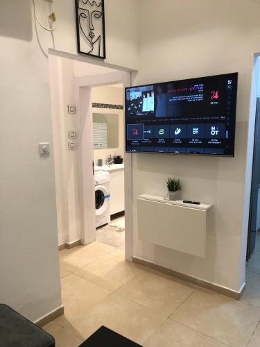 a living room with a flat screen tv on a wall at Boutique Suite Talia in Eilat