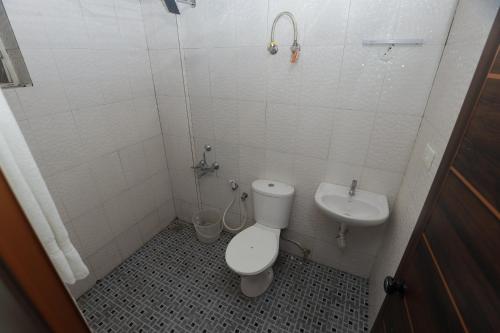 a bathroom with a toilet and a sink at VV ROOMS cochin internationalairport in Nedumbassery