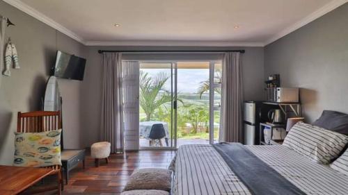 a bedroom with a bed and a sliding glass door at 54 on Asteria 2 in Amanzimtoti