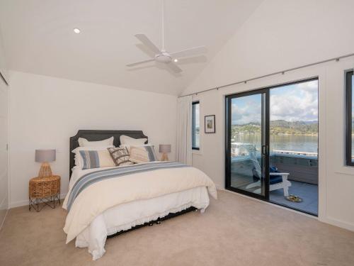 a bedroom with a bed and a view of the water at Tairua Marina Villa in Tairua