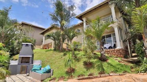 a house with palm trees in front of it at 54 on Asteria 2 in Amanzimtoti