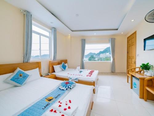 a hotel room with two beds and a window at Lang Chai Hotel - Travel Agency in Cat Ba