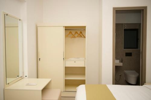 Habitación blanca con cama y espejo en Z Bliss Suites, BKC en Bombay