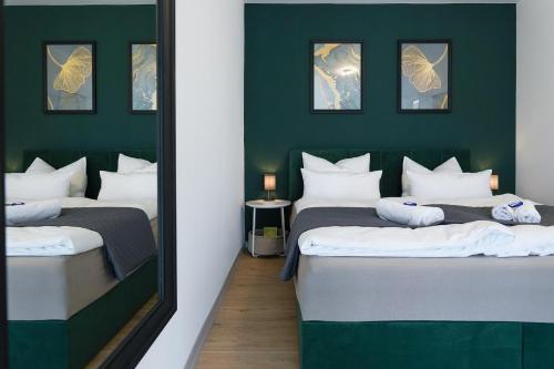two beds in a room with a mirror at CABANA Kreyenbrück - Maisonette Apartments - Parkplatz - Nähe Klinikum - WLAN - Netflix in Oldenburg