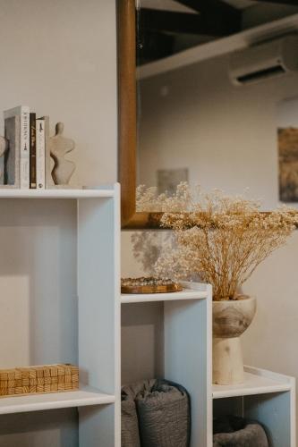 a white shelf with a mirror and a vase at Stacey's Apartment in Hillcrest