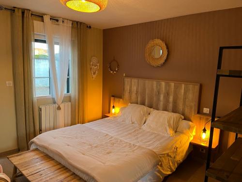 a bedroom with a large bed and a window at La Rose des Vents in Le Crotoy