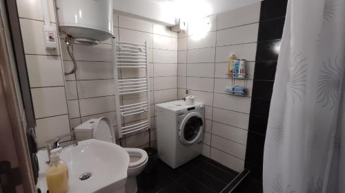 a bathroom with a toilet and a washing machine at apartment to nature B in Ámmos