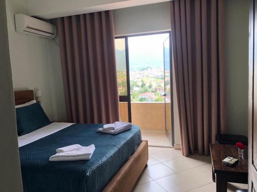 ein Hotelzimmer mit einem Bett mit Handtüchern darauf in der Unterkunft Hotel Agron in Tirana