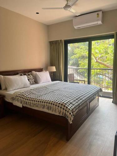 1 dormitorio con cama grande y ventana grande en 108 LazyStays - 2 BHK brand new flat in Arpora, en Arpora