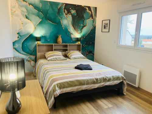 1 dormitorio con 1 cama con una pintura en la pared en Au pied des batteries, en Longues-sur-Mer