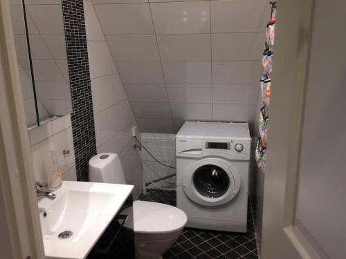 a bathroom with a washing machine and a sink at 2 Bedrooms apartment in a villa, close to nature. in Västerås