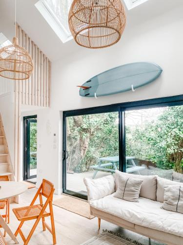 sala de estar con sofá y tabla de surf en la pared en Lowen Tree House, en Truro