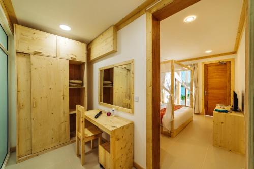 uma casa de banho com um lavatório e uma cama num quarto em WAVE SOUND by 3S Maldives em Maradhoofeydhoo