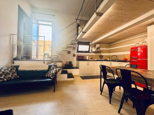 ein Wohnzimmer mit einem Sofa und einem Tisch sowie eine Küche in der Unterkunft Casa Violante in Alghero