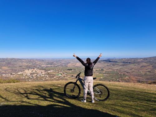 een vrouw die naast een fiets op een heuvel staat bij azienda agrituristica la torretta in Tocco da Casauria