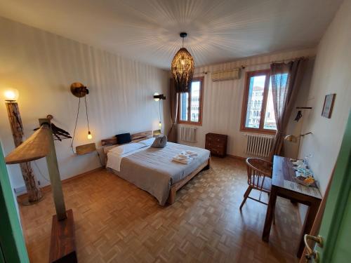 um quarto com uma cama, uma mesa e janelas em Residenza La Veranda a Rialto em Veneza