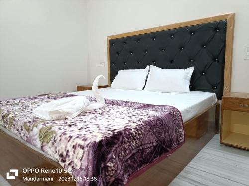 a hotel room with a bed with a blanket on it at Tarangamala Resort in Mandarmoni