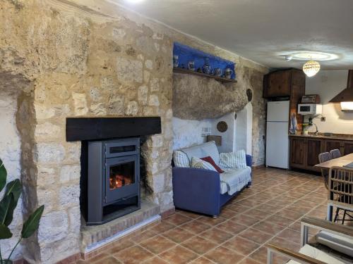 a living room with a stone wall with a fireplace at Casa Rural Alikakaro in Alcalá del Júcar
