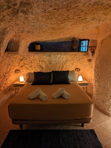 a bedroom with a bed in a stone wall at Casa Rural Alikakaro in Alcalá del Júcar