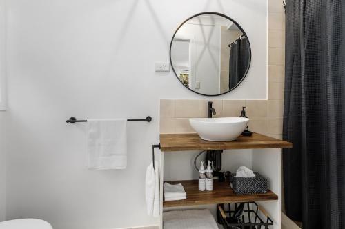 een badkamer met een wastafel en een spiegel bij Rosella's On Springbrook in Springbrook