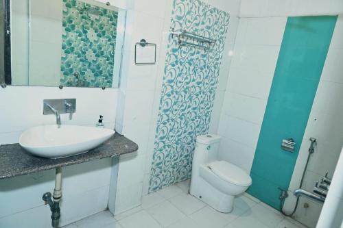 Hotel Varuna Inn في فاراناسي: حمام مع حوض ومرحاض