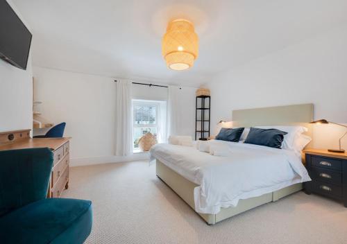 a white bedroom with a large bed and a couch at Rhyd y Fen in Aberaeron