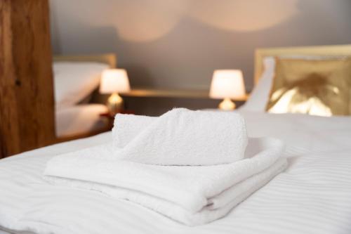 a pile of towels sitting on top of a bed at Dům u města Milána - sedm dveří, sedm světů in Lanškroun