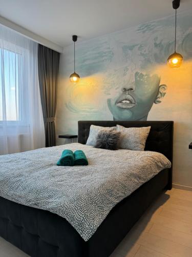 a bedroom with a bed with a painting on the wall at BLACK APARTAMENT in Cluj-Napoca