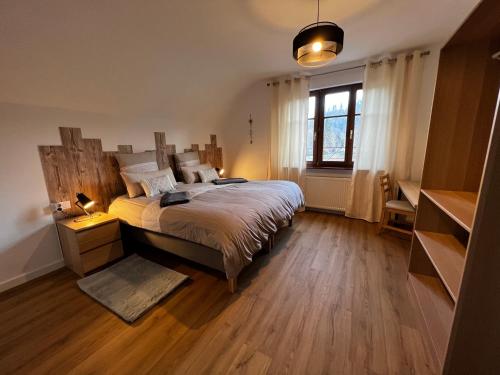 Un dormitorio con una cama grande y una ventana en Maison d'hôtes en forêt avec des chevaux, Domaine du Trèfle d'Or, en Soucht