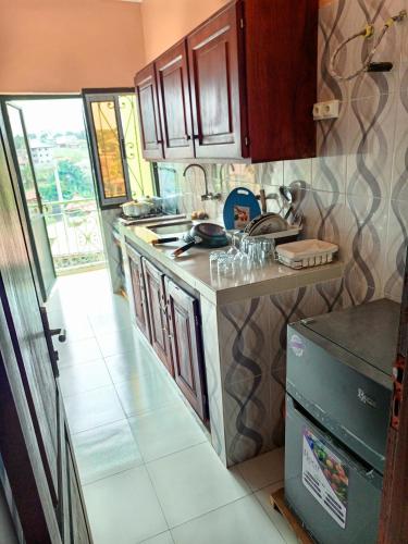une cuisine avec une cuisinière et un comptoir dans l'établissement RÉSIDENCE DES 7 COLLINES, à Yaoundé