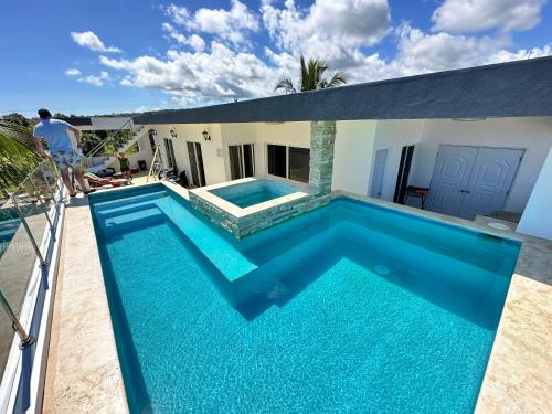 a man standing on the balcony of a house with a swimming pool at Casa Lambí in Cabrera