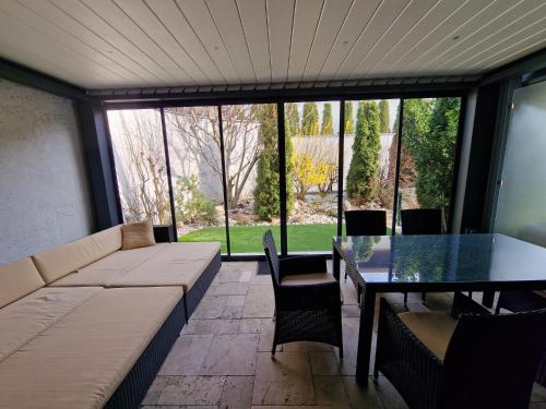 ein Wohnzimmer mit einem Sofa, einem Tisch und Stühlen in der Unterkunft Villapark Pleasure Apartment in Balatonfüred