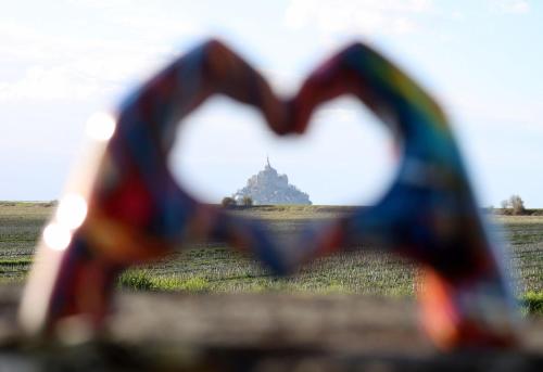 uma vista em forma de coração de um edifício num campo em Vue unique sur le Mont St Michel em Huisnes-sur-Mer